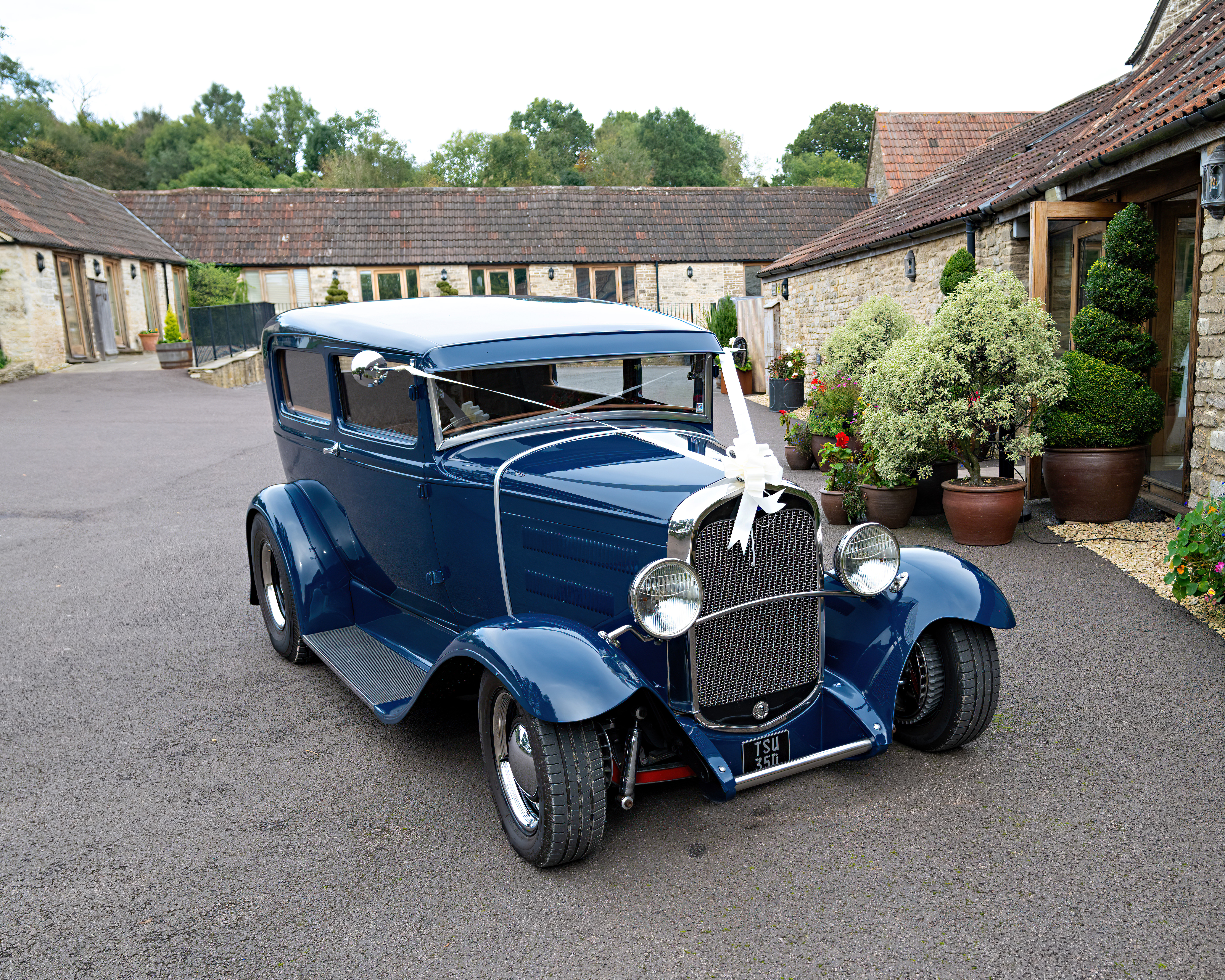 Scene of wedding dressing up hired antique classic car. Outdoor. Not people appear. Garage/stable or shed building.